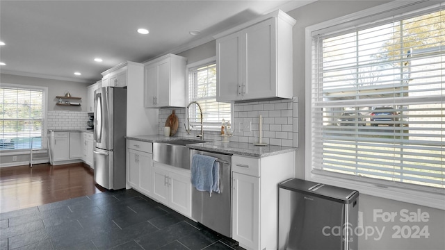 kitchen featuring white cabinets, plenty of natural light, appliances with stainless steel finishes, and tasteful backsplash