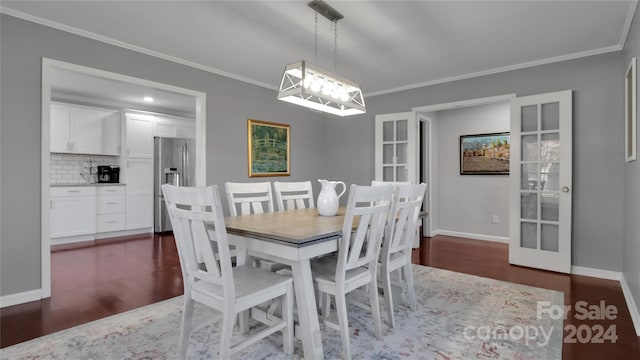 dining space with french doors, crown molding, and dark wood-type flooring