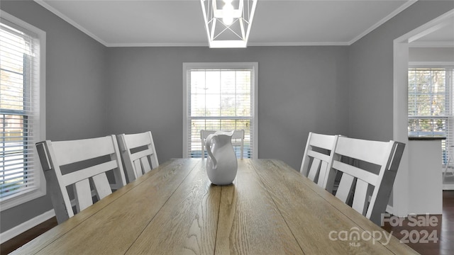 dining space with a notable chandelier, wood-type flooring, and ornamental molding