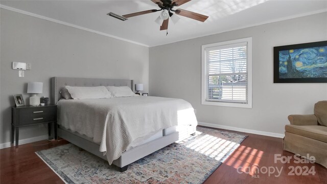 bedroom with ceiling fan, dark hardwood / wood-style floors, and ornamental molding