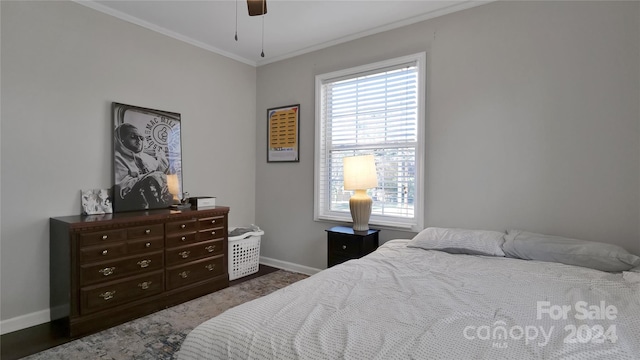 bedroom with multiple windows, ceiling fan, dark hardwood / wood-style flooring, and ornamental molding