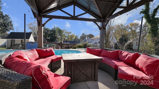 view of patio featuring outdoor lounge area, a fenced in pool, and an outbuilding