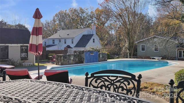 view of pool with a patio area and a diving board