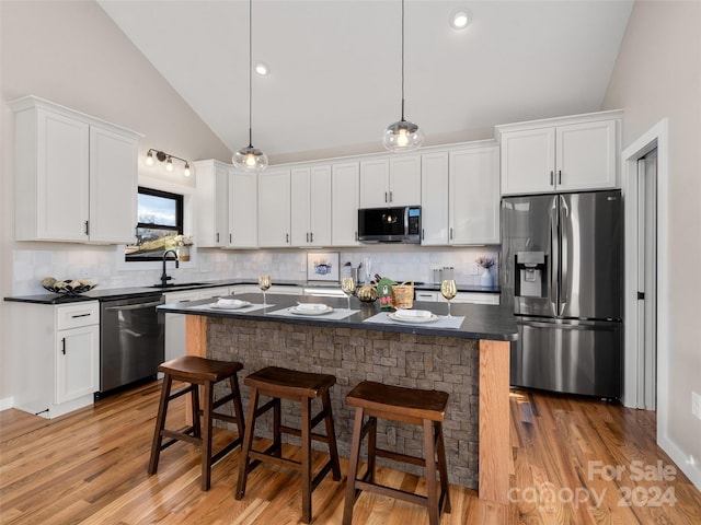 kitchen with white cabinets, light wood-type flooring, and stainless steel appliances