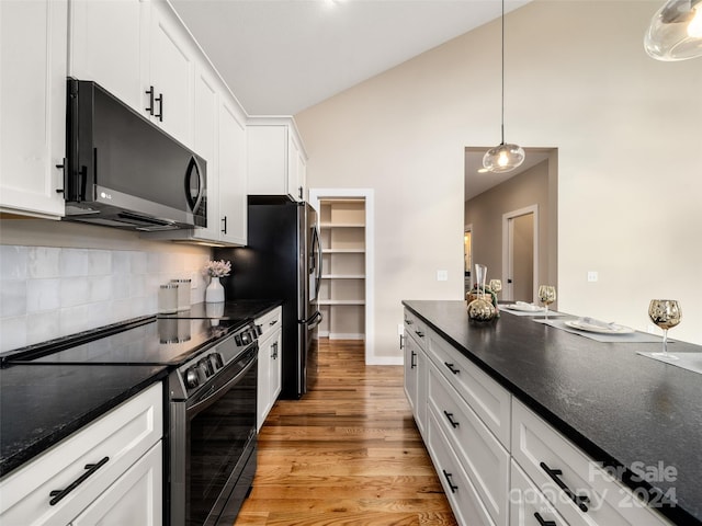 kitchen with lofted ceiling, hanging light fixtures, light hardwood / wood-style flooring, black / electric stove, and white cabinetry