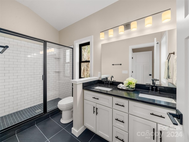 bathroom featuring tile patterned floors, vanity, vaulted ceiling, and walk in shower