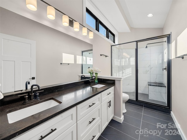 bathroom with tile patterned floors, lofted ceiling, toilet, vanity, and a shower with shower door