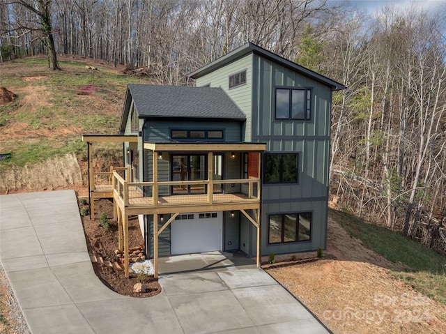 contemporary home featuring a garage and a wooden deck