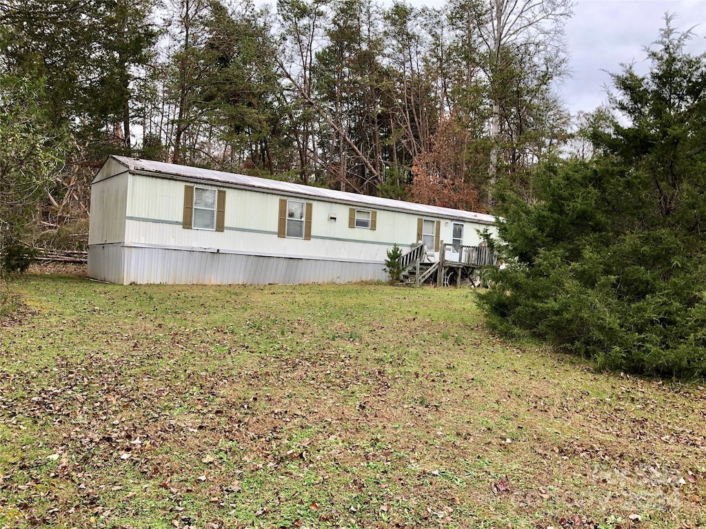 view of front of property featuring a front yard and a wooden deck