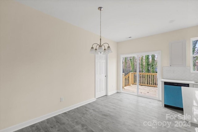 unfurnished dining area featuring light hardwood / wood-style flooring and an inviting chandelier