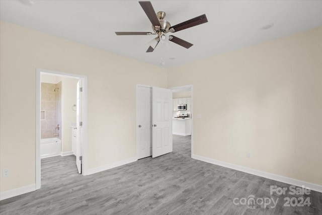 unfurnished bedroom featuring ceiling fan, light hardwood / wood-style flooring, and ensuite bath