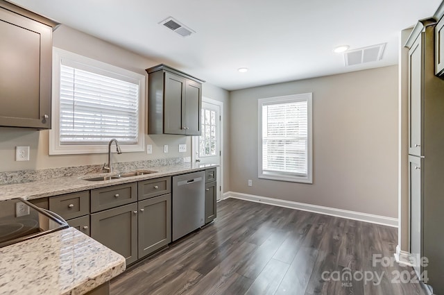 kitchen with light stone counters, stainless steel dishwasher, dark wood-type flooring, and sink