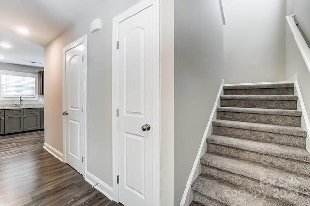 stairs featuring wood-type flooring and sink