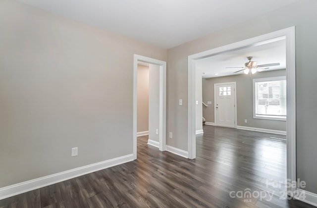 empty room with dark hardwood / wood-style floors and ceiling fan