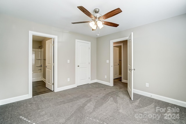 unfurnished bedroom with carpet flooring, ceiling fan, a closet, and ensuite bath