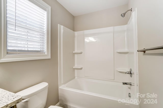 bathroom featuring shower / tub combination and toilet