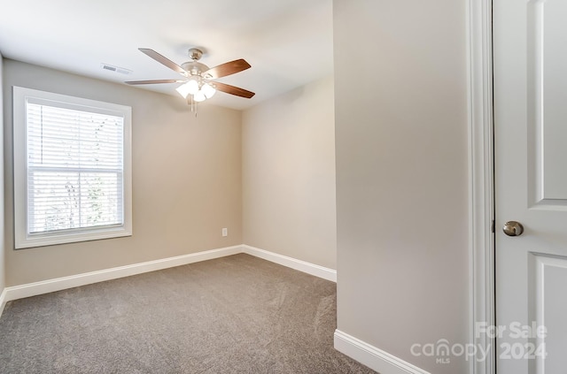 carpeted spare room with ceiling fan