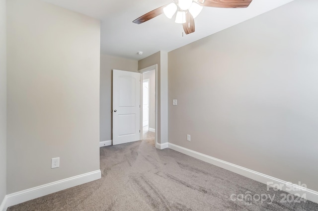 carpeted spare room featuring ceiling fan