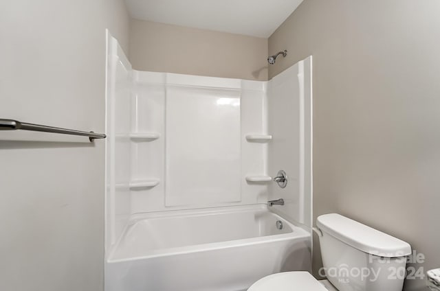 bathroom with toilet and bathing tub / shower combination