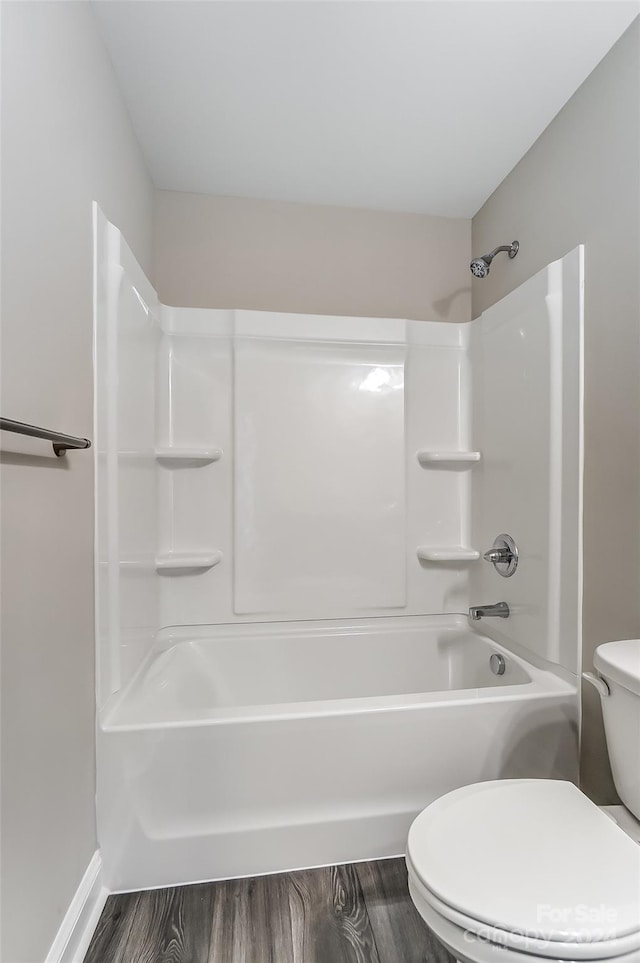 bathroom featuring hardwood / wood-style floors, toilet, and shower / washtub combination