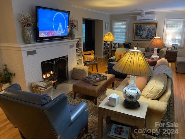 living room with hardwood / wood-style flooring, ornamental molding, a fireplace, and a wall unit AC