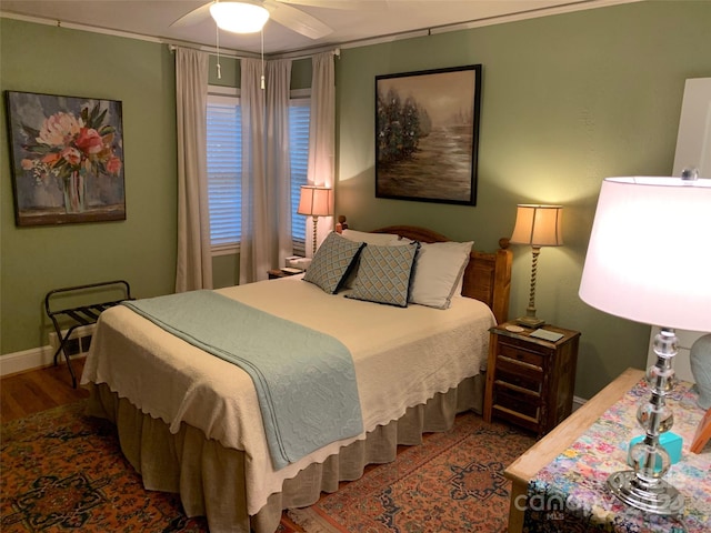 bedroom featuring hardwood / wood-style flooring, ceiling fan, and ornamental molding