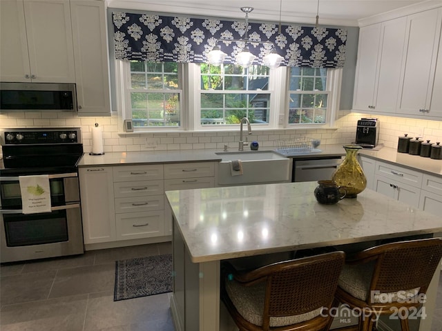 kitchen with stainless steel appliances, white cabinetry, and tasteful backsplash