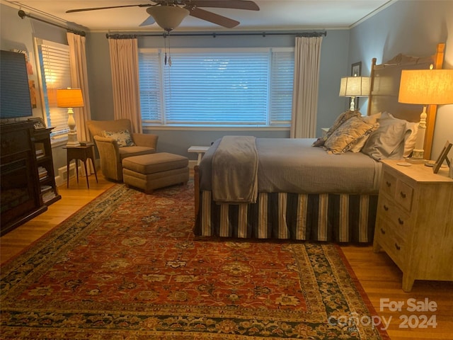 bedroom featuring ceiling fan, crown molding, and light hardwood / wood-style flooring