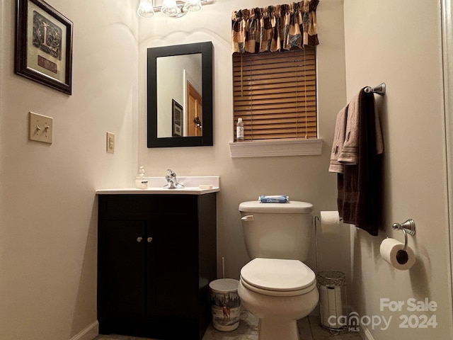 bathroom featuring tile patterned flooring, vanity, and toilet