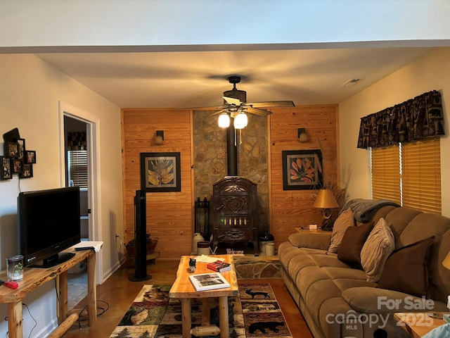369 Pinecrest Cir, Troy, NC 27371 - living area with a wood stove, ceiling fan, wooden walls, and wood finished floors