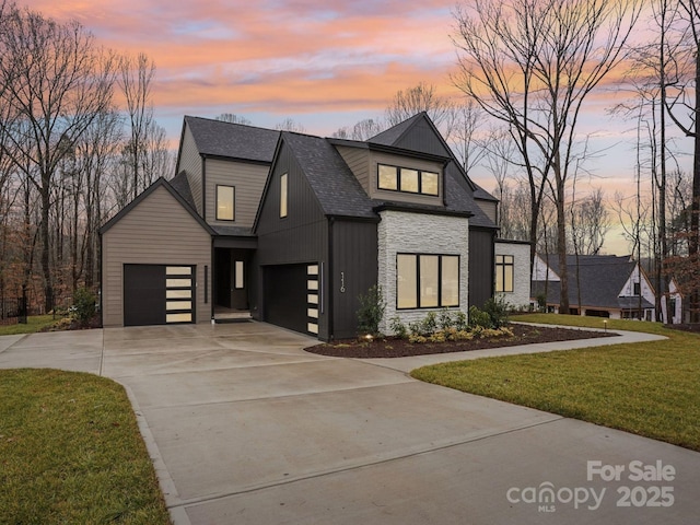 view of front of home with a garage and a yard