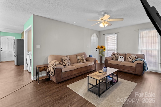 living room featuring ceiling fan, separate washer and dryer, a textured ceiling, and dark hardwood / wood-style flooring