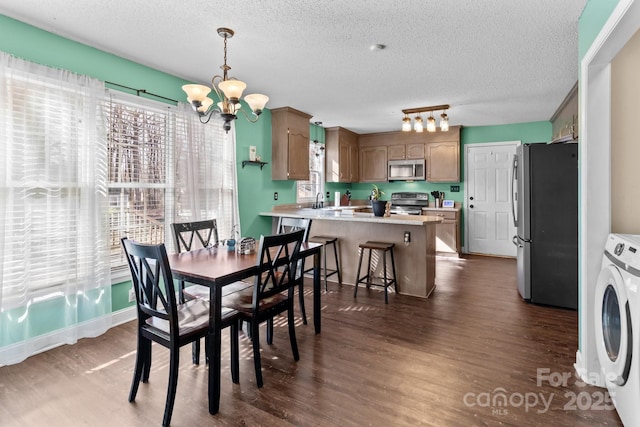 dining room featuring dark hardwood / wood-style flooring, sink, a textured ceiling, and an inviting chandelier