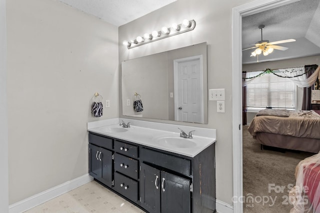 bathroom featuring vanity, ceiling fan, lofted ceiling, and a textured ceiling