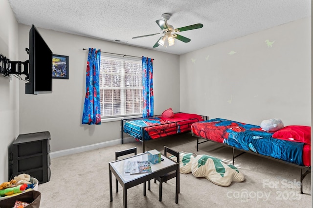 bedroom with ceiling fan, carpet, and a textured ceiling