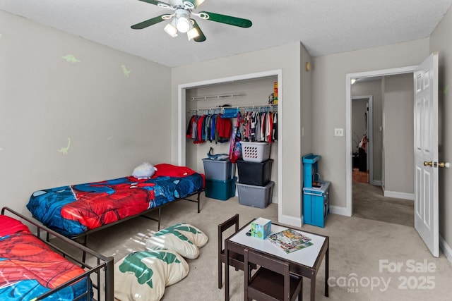 bedroom with ceiling fan, a closet, a textured ceiling, and carpet