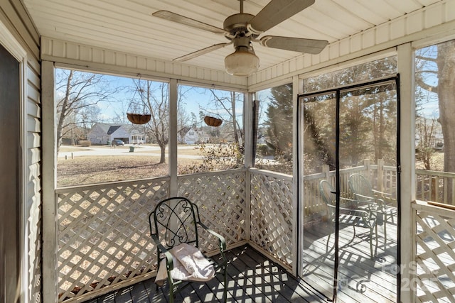 unfurnished sunroom featuring a wealth of natural light and ceiling fan