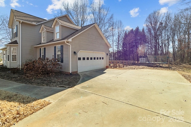 view of property exterior with a garage and a trampoline