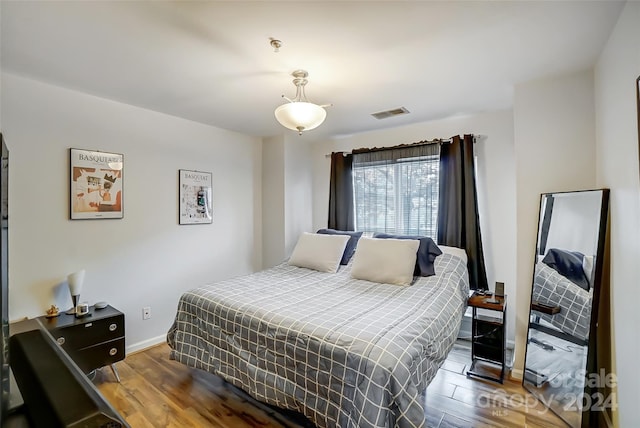 bedroom with dark hardwood / wood-style floors