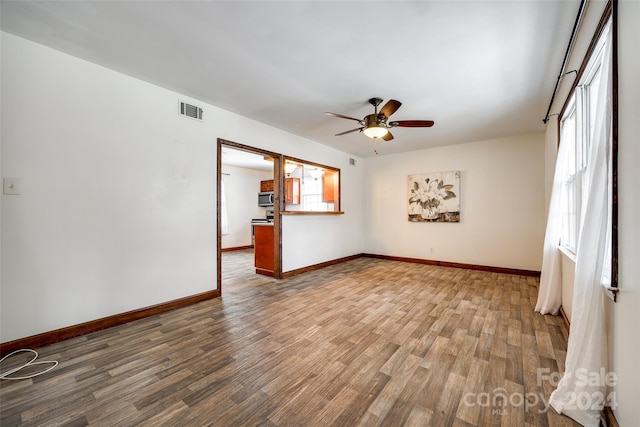 unfurnished living room featuring wood-type flooring and ceiling fan