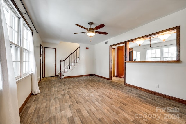 unfurnished living room featuring ceiling fan and light wood-type flooring