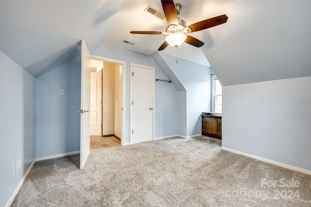 additional living space with light carpet, ceiling fan, and vaulted ceiling