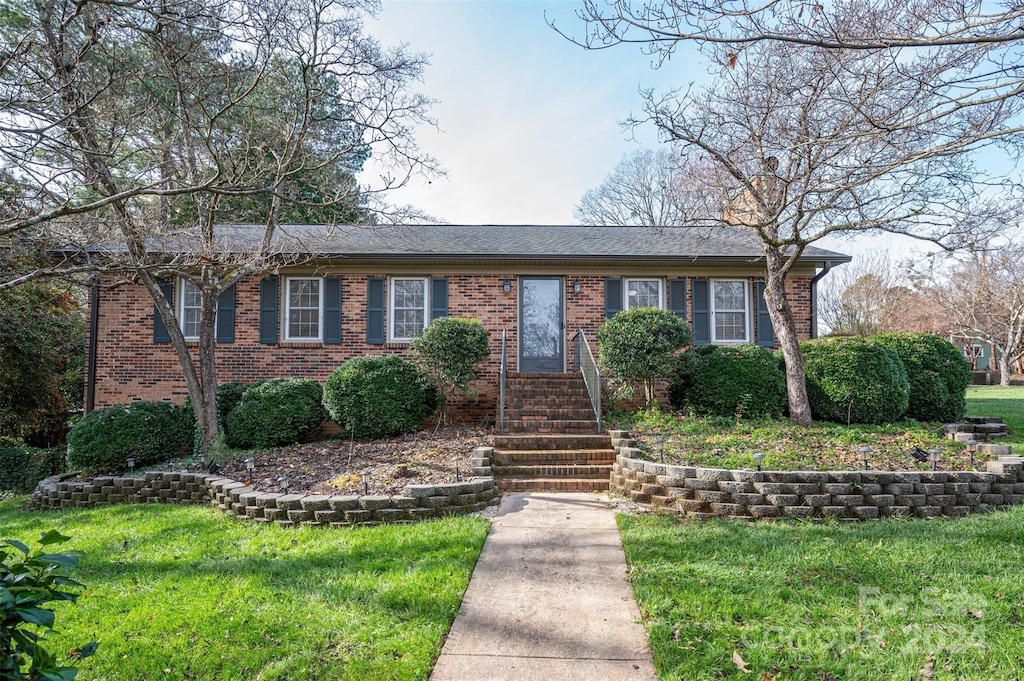 single story home featuring a front lawn