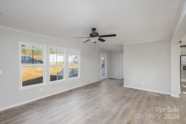 empty room with a textured ceiling, ceiling fan, light hardwood / wood-style floors, and crown molding