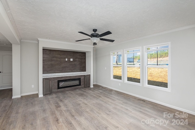 unfurnished living room with ceiling fan, crown molding, light hardwood / wood-style floors, a textured ceiling, and a tiled fireplace