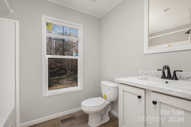 bathroom featuring vanity, hardwood / wood-style flooring, toilet, and crown molding