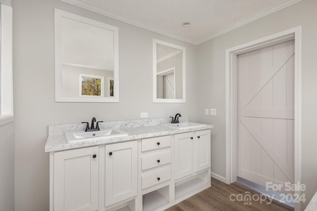 bathroom with hardwood / wood-style flooring, vanity, and crown molding