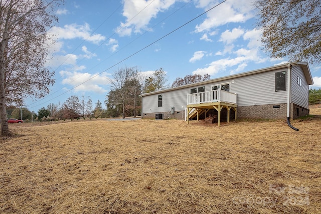 rear view of property featuring a deck and central air condition unit