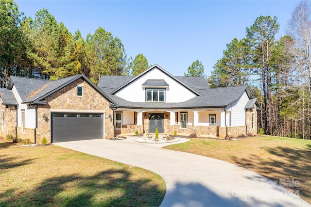 view of front of home with a garage, covered porch, and a front lawn