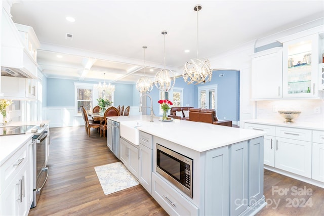 kitchen featuring pendant lighting, white cabinetry, a center island with sink, and stainless steel appliances